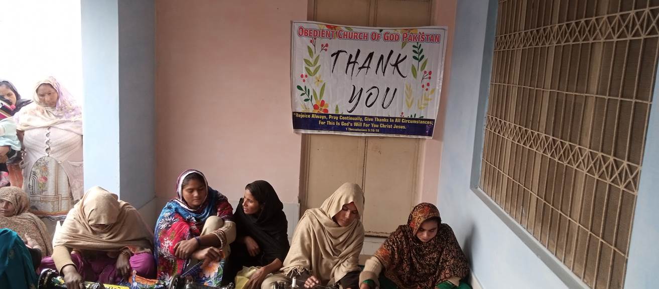 A group of people sitting in a room with a sign

Description automatically generated with low confidence